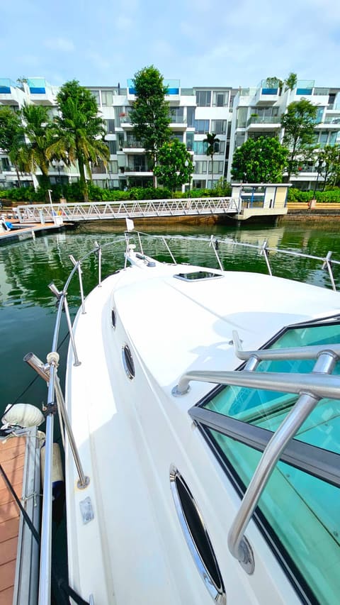 Artemis 1 bow-on at her ONE°15 berth, with the Sentosa Cove residences behind