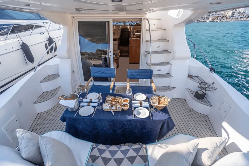 Aft deck of a Majesty 50 laid for lunch under the overhang, with steps up to the flybridge