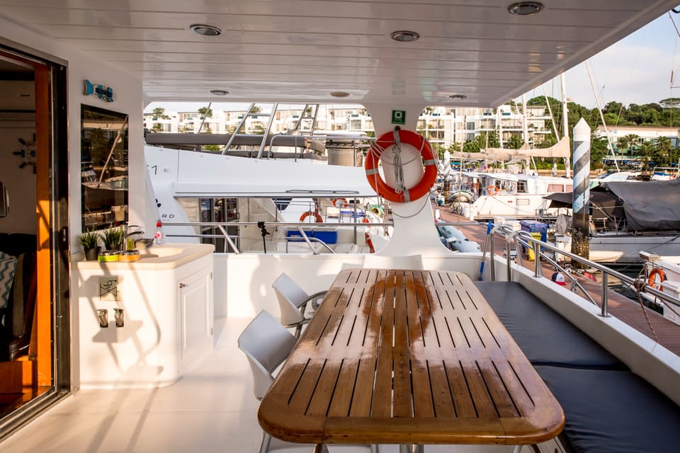 Sardinia's aft deck at golden hour, with the sink and counter to one side of the dining table