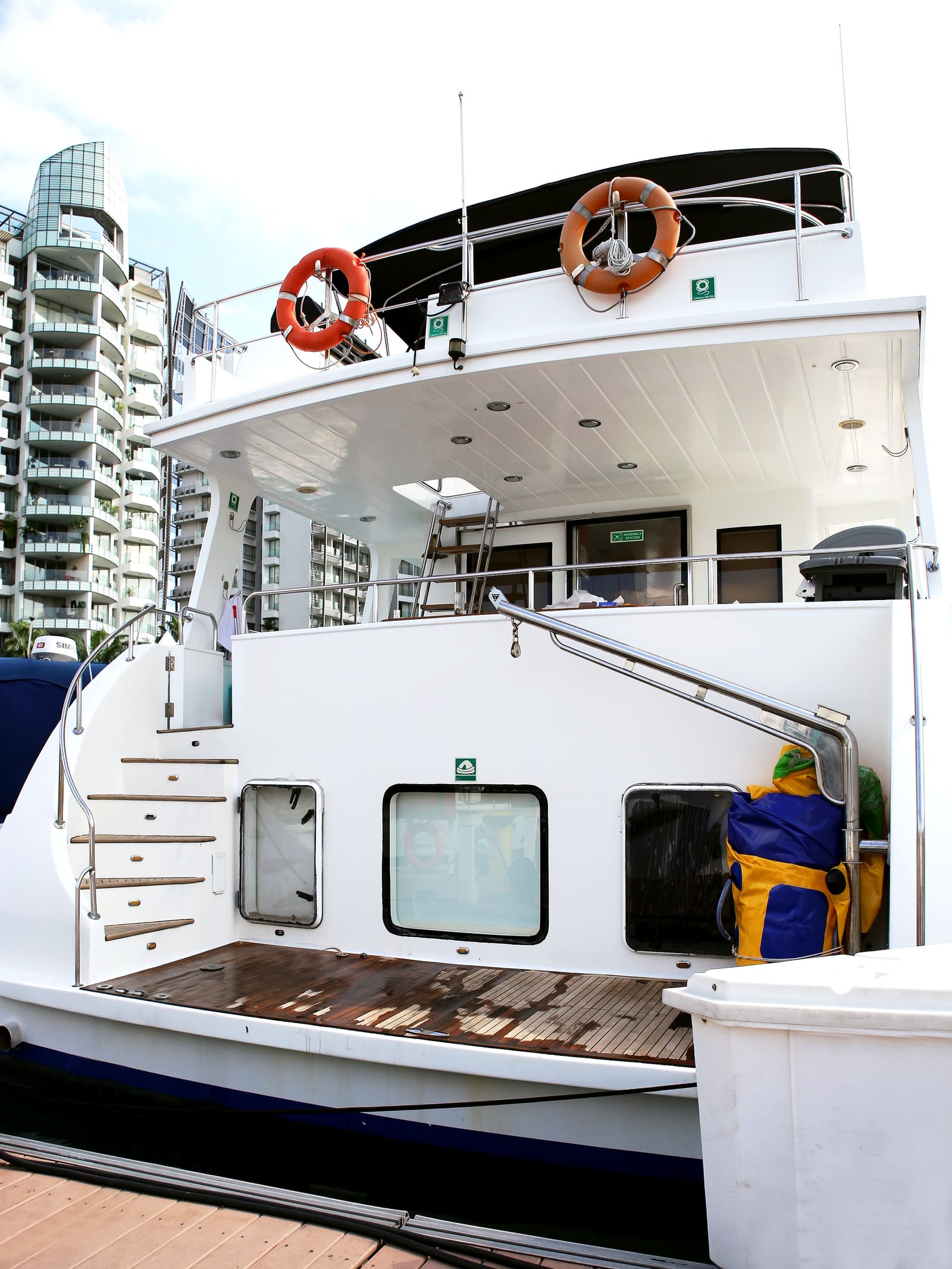 Sardinia alongside at ONE°15 Marina, showing the teak boarding platform and steps up to the aft deck