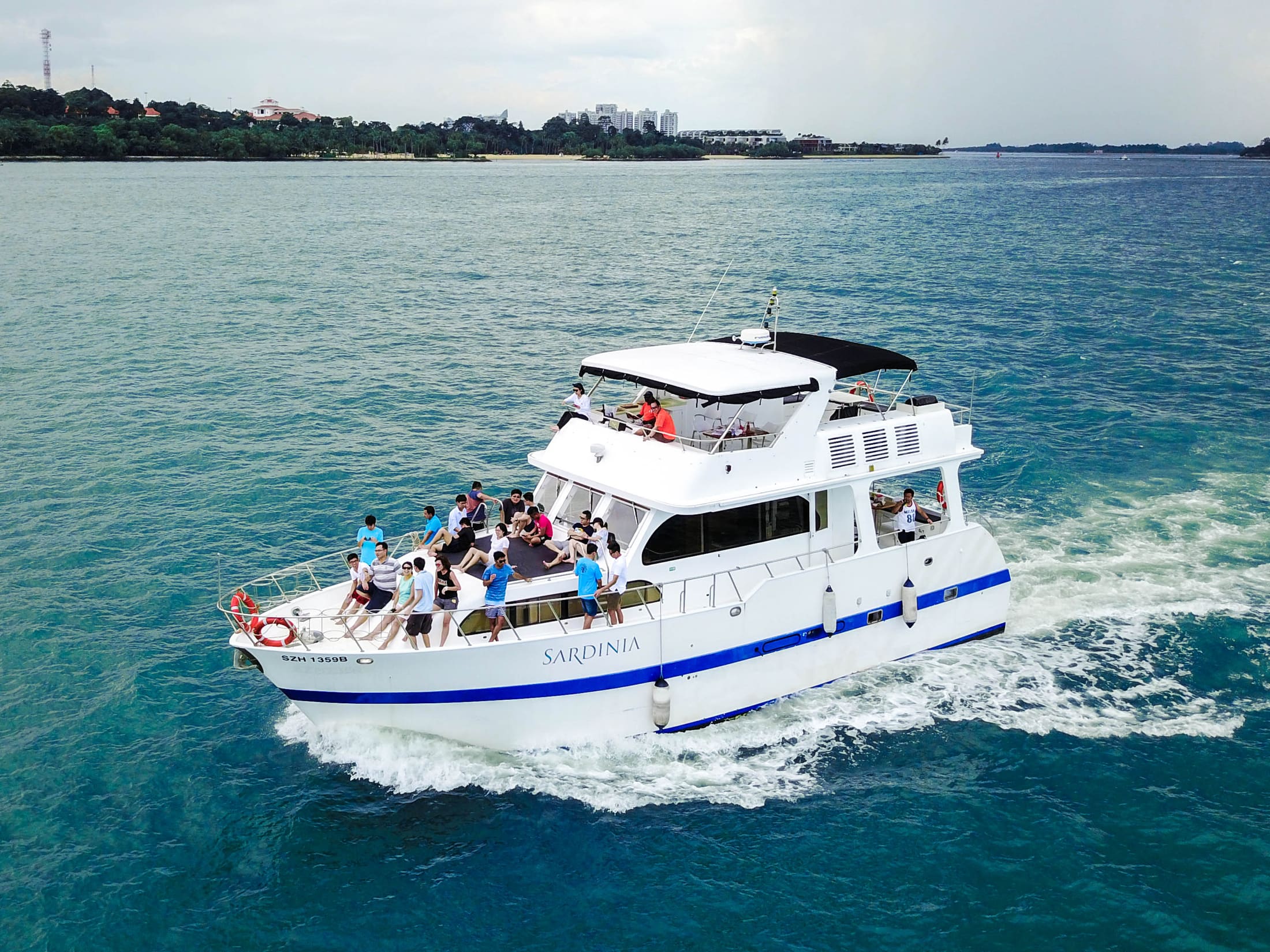 Sardinia underway off the Southern Islands with around twenty guests seated on the bow sun pad