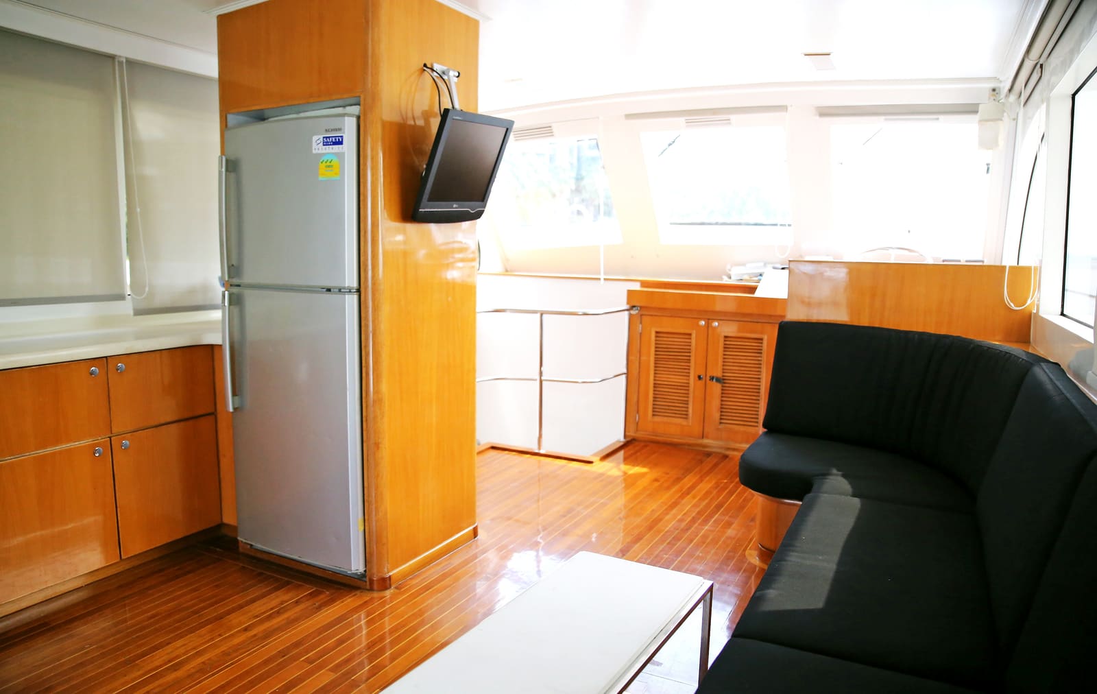 Air-conditioned saloon with the full-height fridge, wall-mounted television and bench seating
