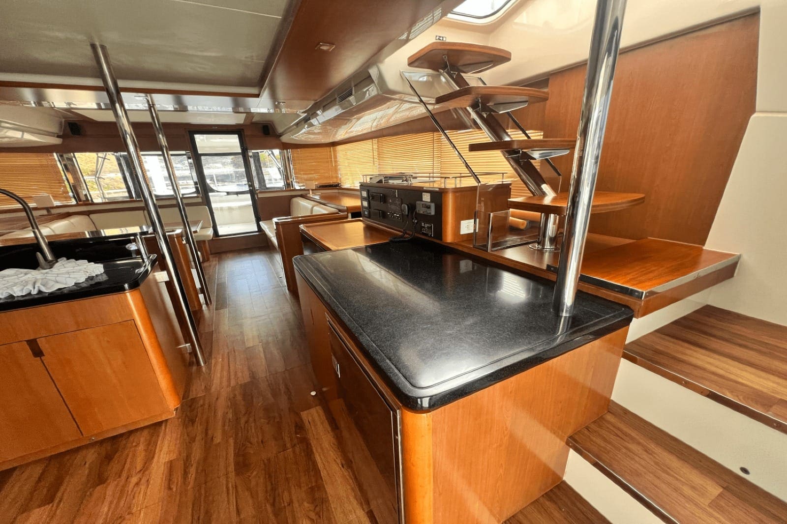 Galley island with a granite worktop, sink and hob, and steps down to a hull